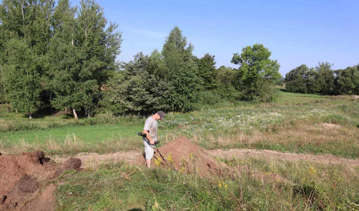 Konrad sprawdza wykrywaczem powierzchnię wykopu