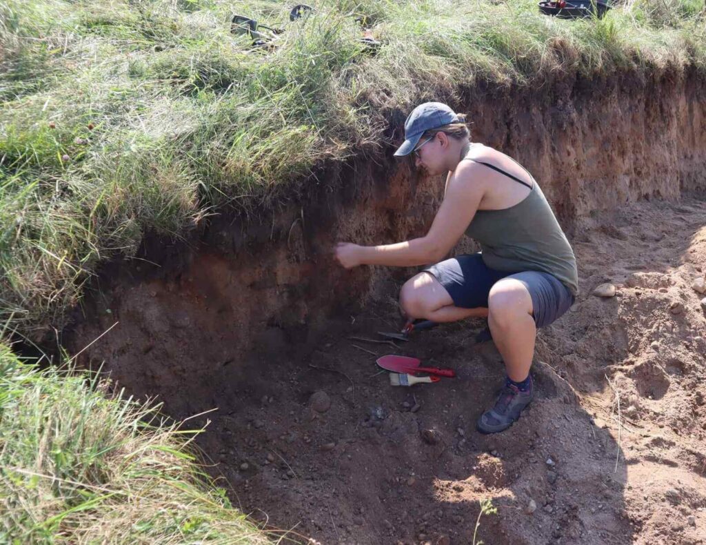 Monika w wykopie doczyszcza profil do zdjęcia