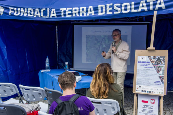 _DSC6356 Wykład prof. Czachorowskiego, biologa z Olsztyna, wykładowca stoi w namiocie wykładowym, przed nim słuchacze siedzą