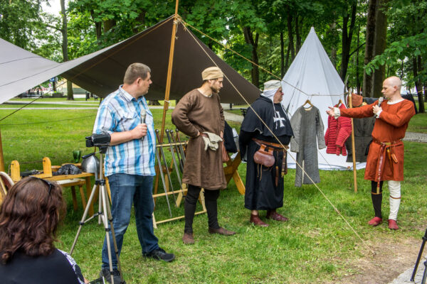 _DSC6505 Pokaz oporządzenia joannitów, widać tłumacza i rekonstruktorów pokazujących swoje stroje