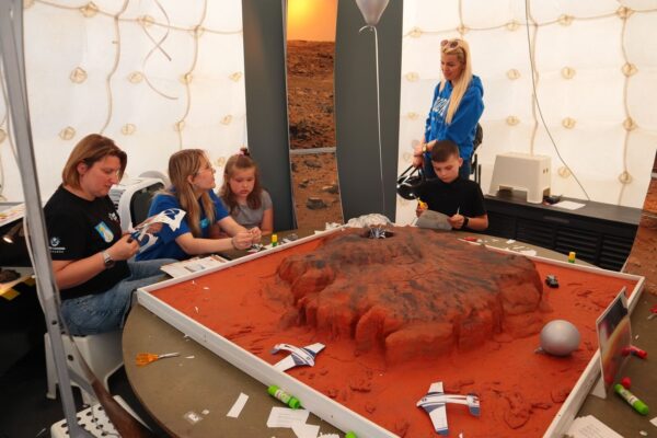 IMG_0651 uczestnicy festiwalu w namiocie marsjańskim wycinają modele łazików, na środku model powierzchni Marsa