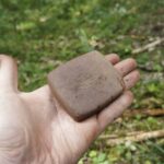 krzesak specyficznie obrobiony w kształcie prostopadłościanu leżący na dłoni