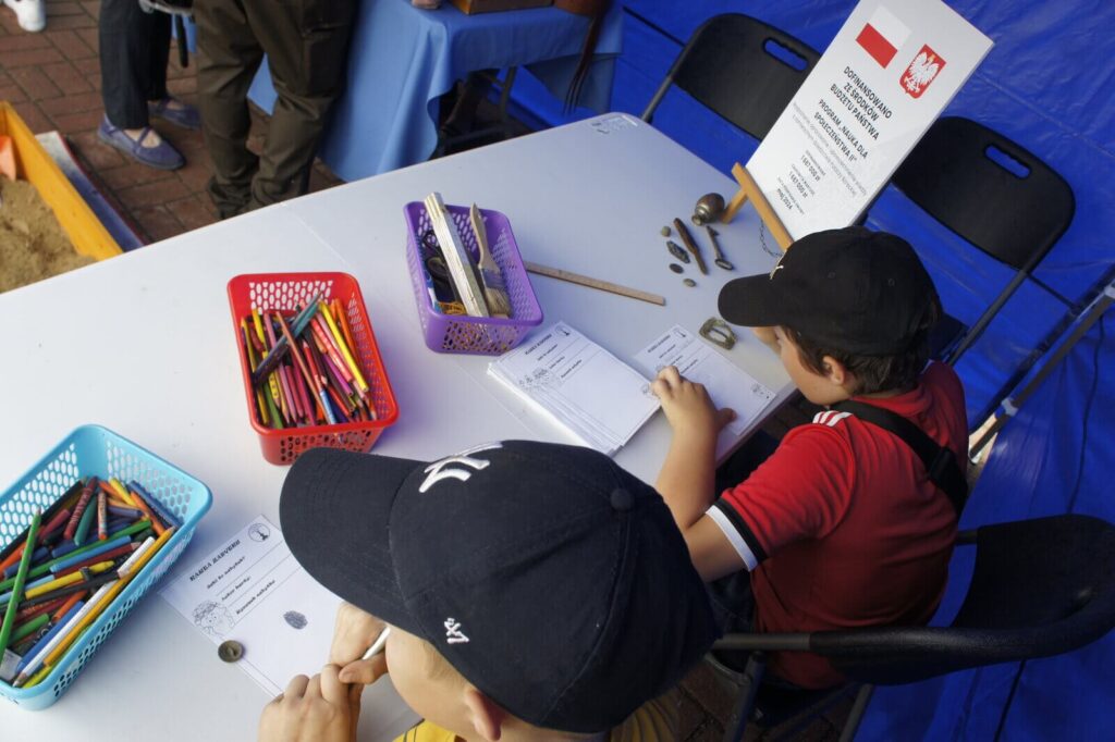 dzieci rysują zabytki odkryte w piaskownicy