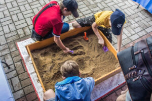 dzieci buszują w piaskownicy w poszukiwaniu skarbów