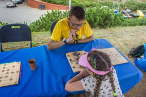 Marcin gra w dawną grę planszową z dziewczynką