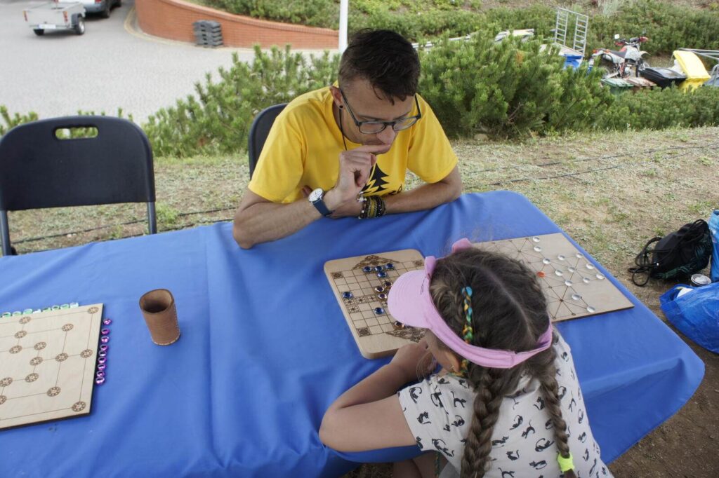 Edukator gra w dawną grę planszową z dziewczynką.