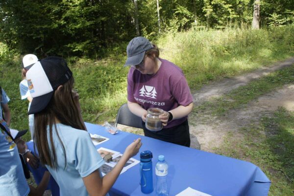 Ania omawia zadanie na swoim stoisku archeologicznym - profil ziemi wykopu