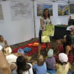 Monika rozdaje dzieciom rysunki do gry edukacyjnej