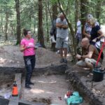 Iwona opowiada gościom o badaniach na wykopie.