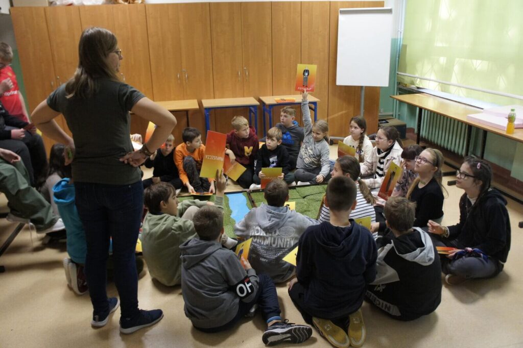 Edukatorka słucha zgłaszających się graczy