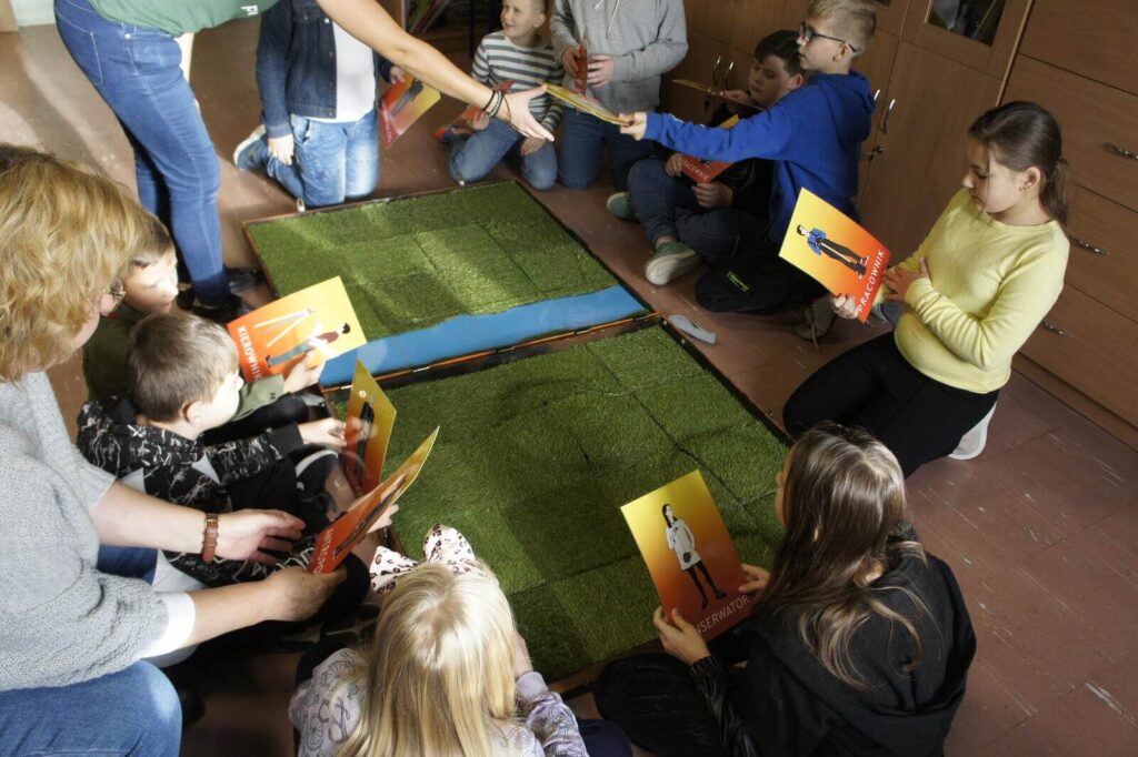 Uczniowie oglądają karty postaci