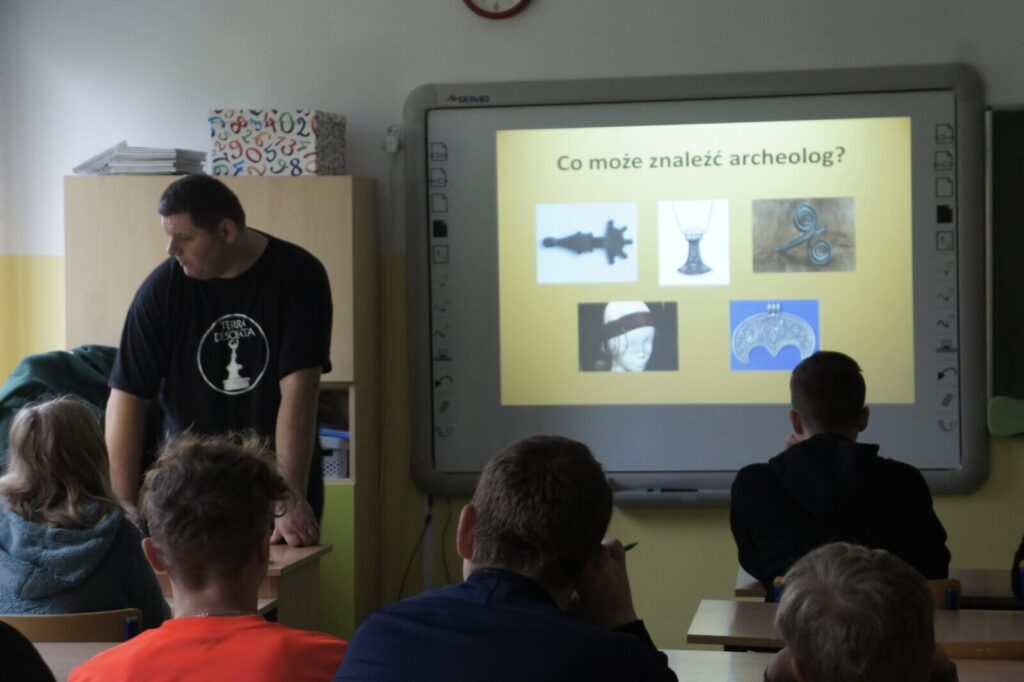 Uczniowie słuchają prelekcji o archeologii