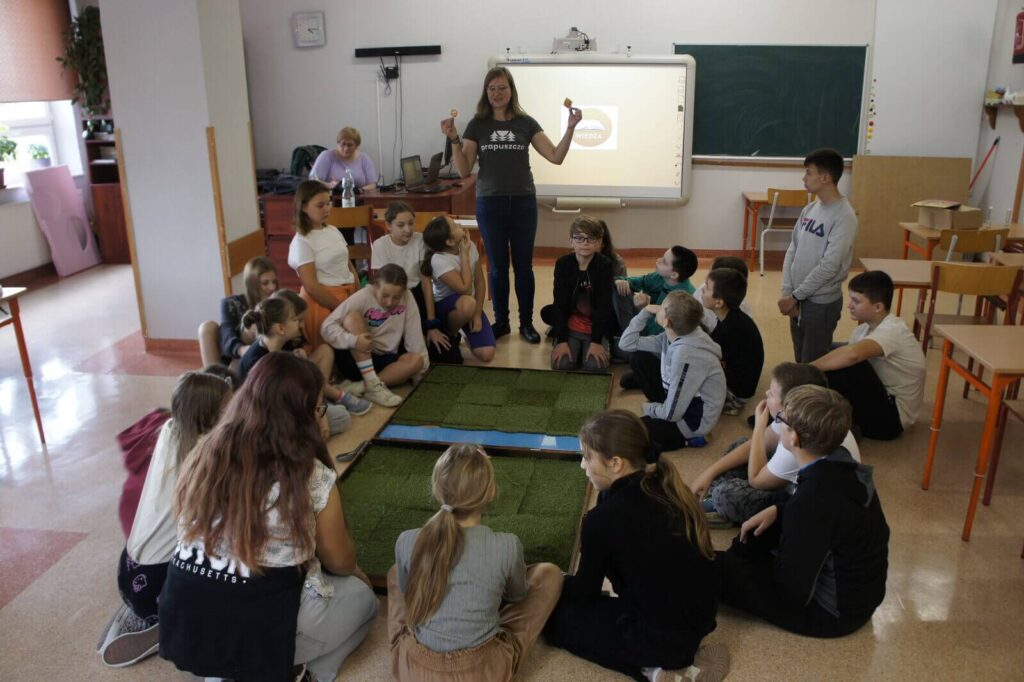 Edukatorka tłumaczy uczniom tajniki archeologii