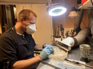 Maciej konserwuje zabytek metalowy.