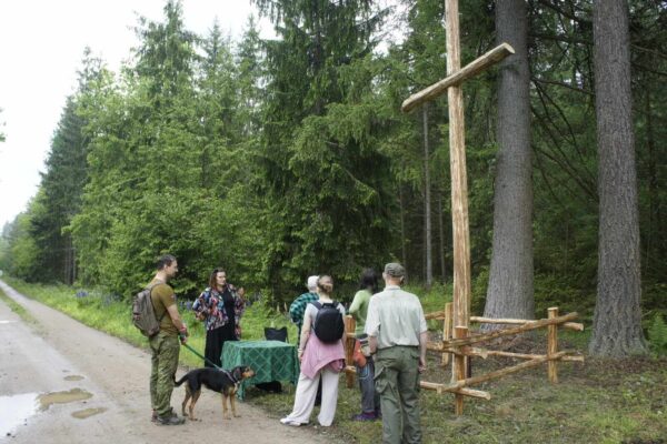 Gracze spotykają wdowę po leśniku przy drewnianym krzyżu i rozwiązują zadanie na jej stanowisku.