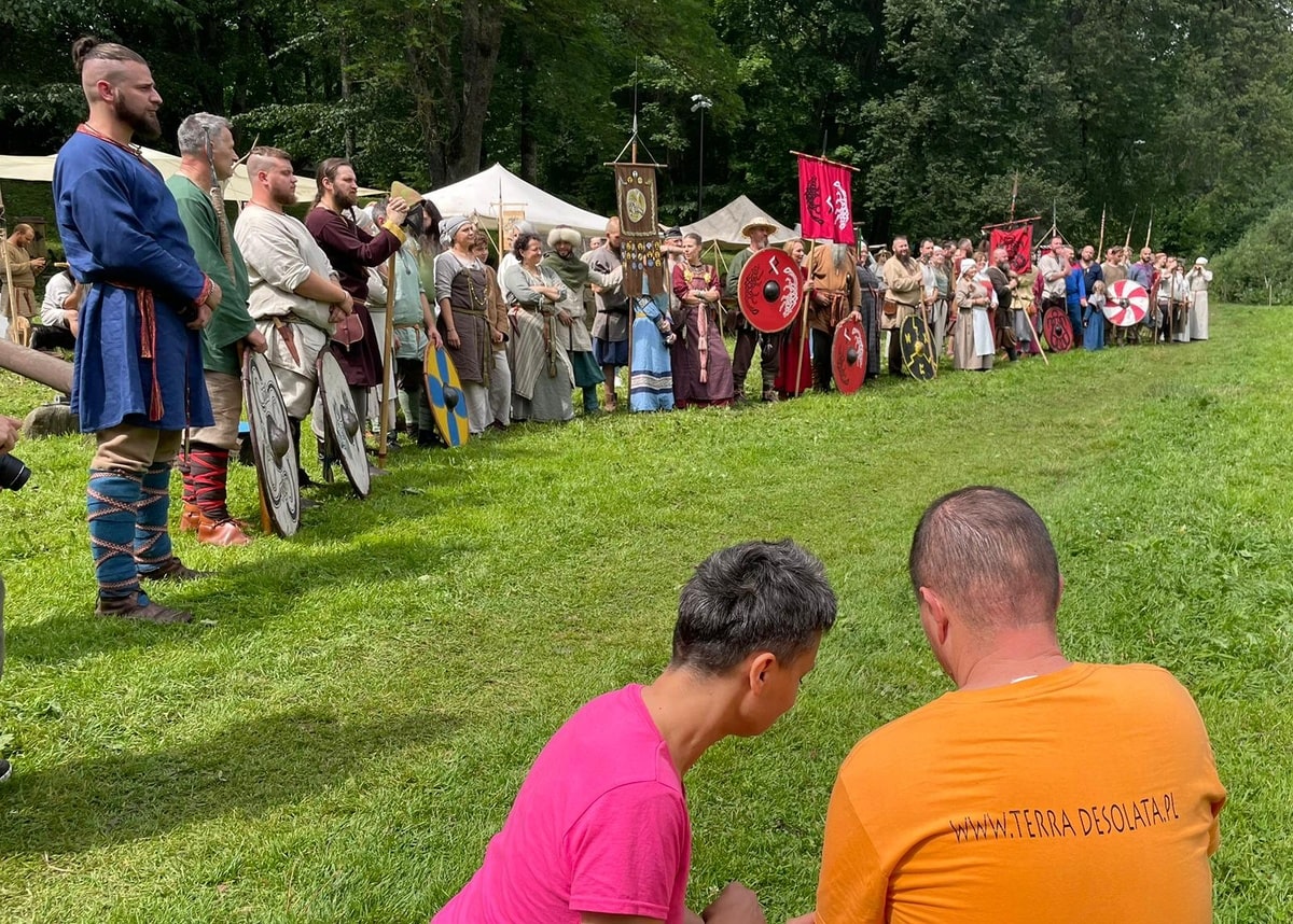 Ania i Bartek nagrywają stojących w rzędzie rekonstruktorów.