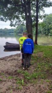 Ania i Bartek stoją plecami do aparatu na tle jeziora.