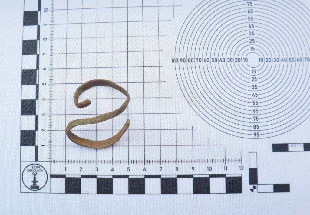 taśma zgięta jak serpentyna leży na podkładce ze skalą