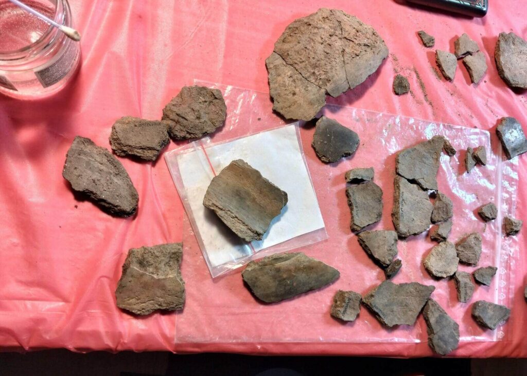 Na stole leżą fragmenty ceramiki do sklejania.