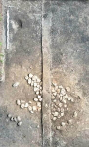 widok z góry na palenisko przecięte świadkiem, kamienie rozrzucone nierównomiernie