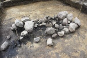 Odczyszczone duże kamienie paleniska ułożone w podłużny stos