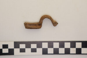 Fragment zapinki, ma kształt jak ślimak winniczek