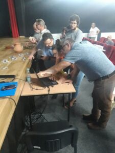 Goście i prowadzący stojąc pod sceną sprawdzają dane w laptopie