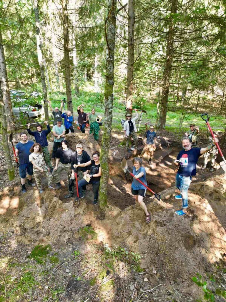 Zdjęcie grupowe ekipy wykopowej na wykopie zrobione przez dron.
