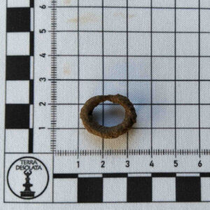 Okrągła klamra leży na podkładce z miarką