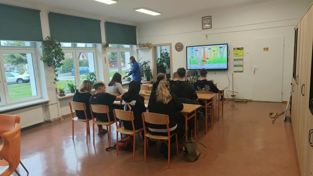 Widok z tyłu na uczniów podczas zajęć archeologicznych.