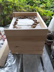 Drewniany pojemnik z szufladkami na poszczególne partie urny, które rozpadły się podczas eksploracji