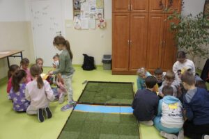 Dzieci w dwóch grupach naradzają się zanim rozpoczną grę.