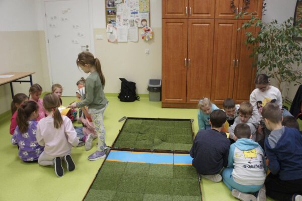 Dzieci w dwóch grupach naradzają się zanim rozpoczną grę.