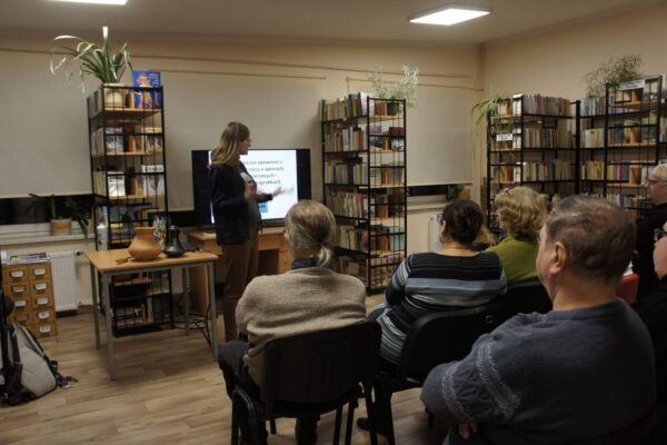 Zdjęcie z tyłu sali na prelegentkę i słuchaczy.