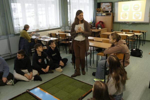 Monika rozmawia z uczniami podczas gry.
