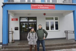 Monika i Piotrek pozują na tle szkoły w Wieliczkach.