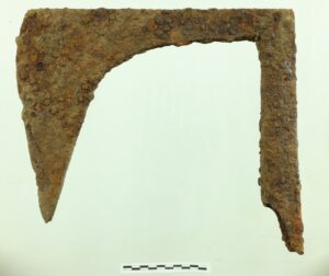 Żelazny zardzewiały topór, największy z odkrytych. Ma długi ostro zakończone ostrze