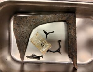 Największy topór wraz z ostrogami leży w misce służącej do kąpieli wodnej podczas konserwacji.