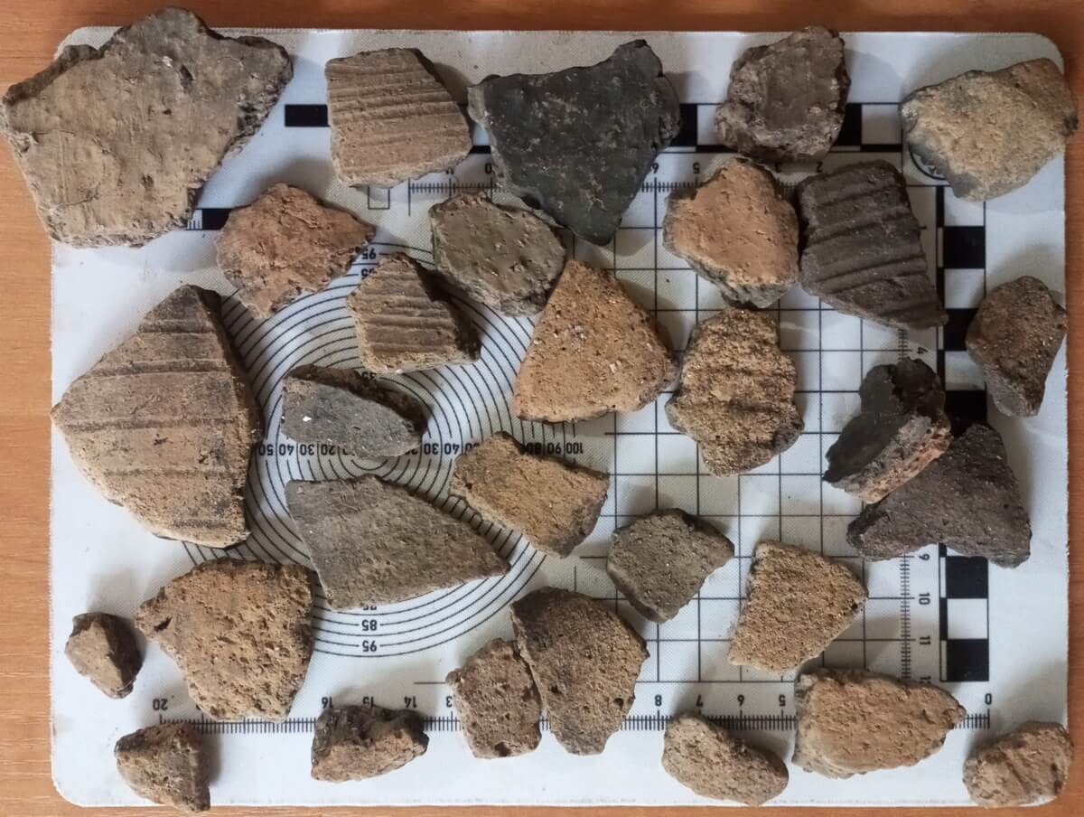 Na stole leżą kawałki naczyń ceramicznych jak puzzle